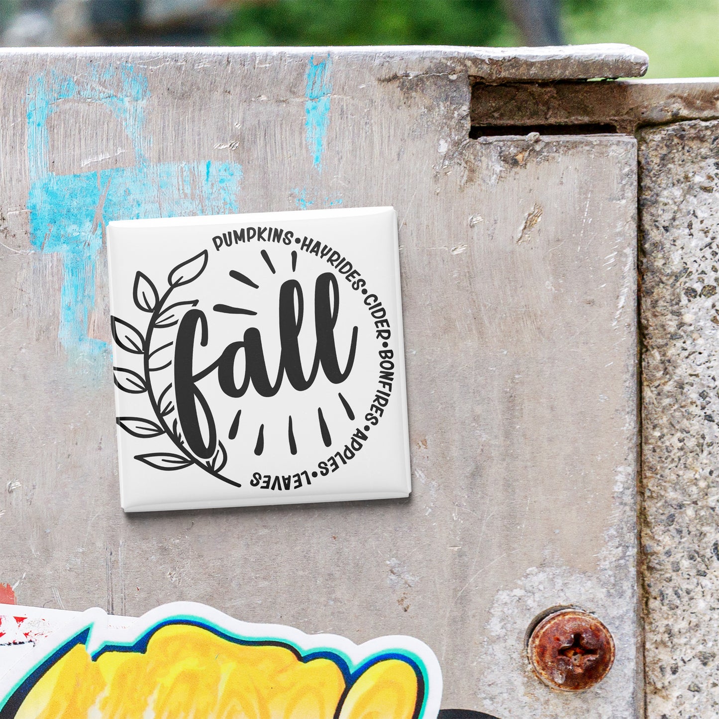 A white tile with a black and white graphic design featuring the word "fall" surrounded by a decorative leaf and the phrase "Pumpkins-Havrils-Cider-Bonfires" in a stylized font.