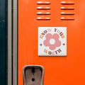 a vibrant orange wall with a sticker that reads "KNOW YOUR WORTH" in bold letters.