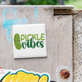 a sticker with the text "Pickle Vibes" on a concrete surface.