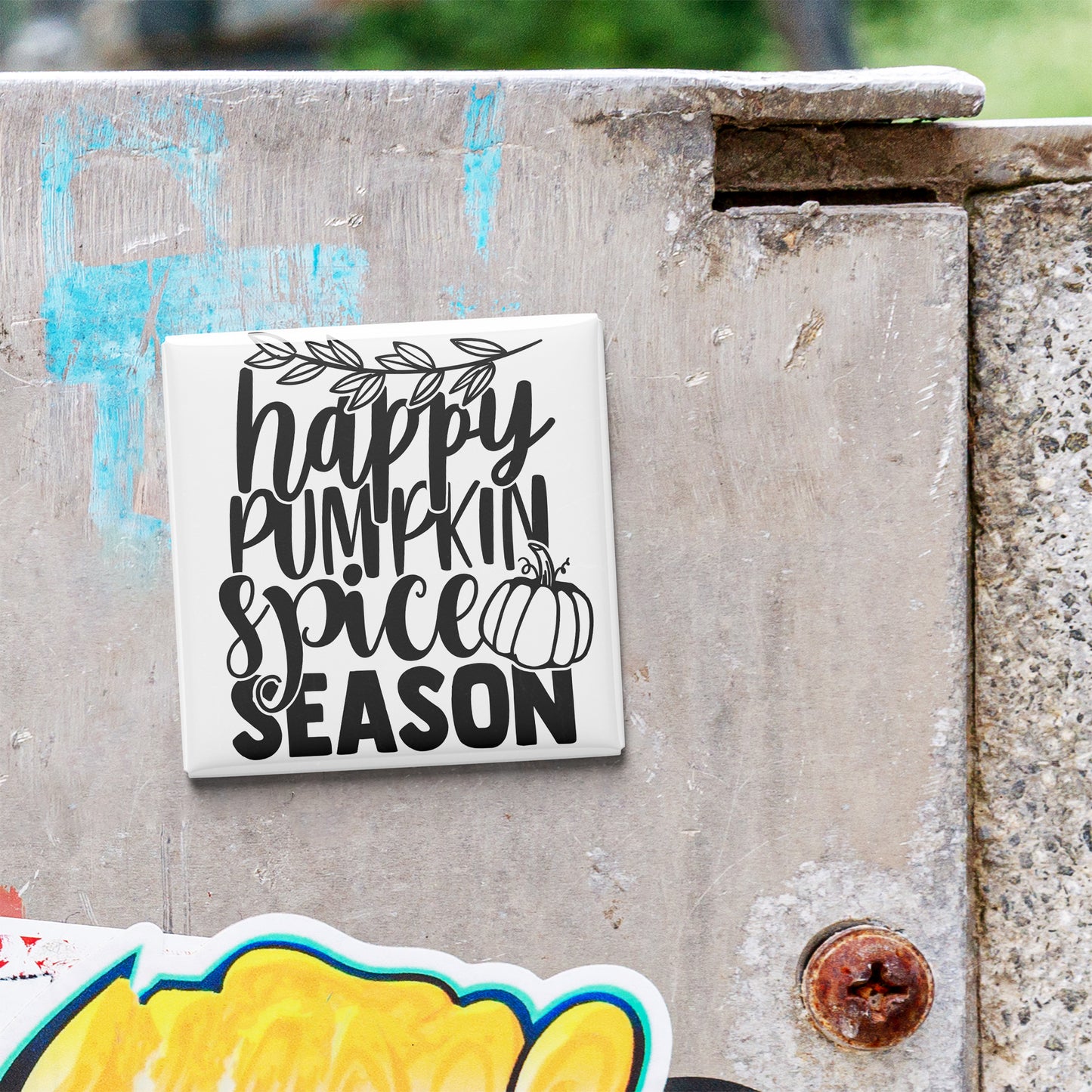 A white sign with black text that says "happy pumpkin spice season" is attached to a concrete wall.
