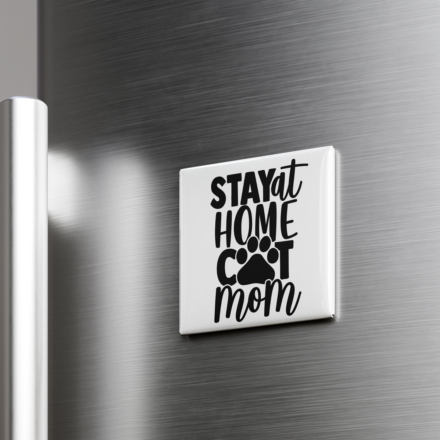 A white refrigerator door with a black and white sticker that says "STAY AT HOME COT MOM".