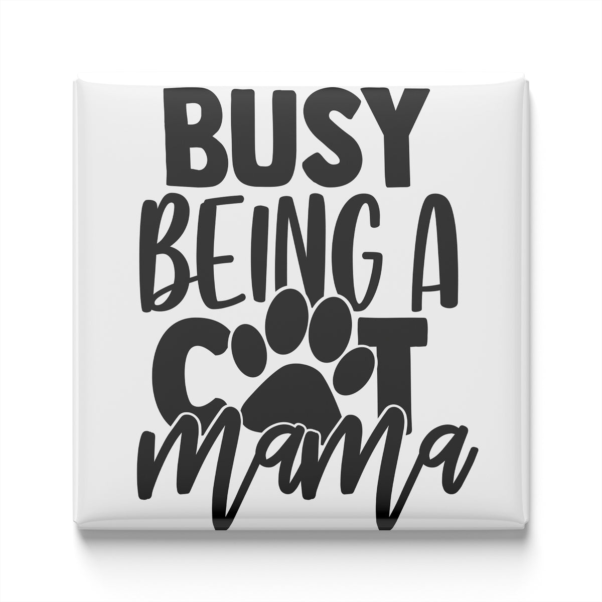 the text "BUSY BEING A COT MAMA" in a stylized font, with a paw print symbol replacing the letter "C".