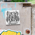 A white tile with the text "fresh baked pies" is attached to a concrete wall.