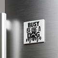 A white refrigerator magnet with the text "BUSY BEING A DOG MAMA" printed on it.