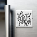A white refrigerator magnet with the text "Live Love Smile" in a stylized font.