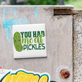 A sticker with a cartoon pickle and the text "YOU HAD ME ALL PICKLES" is attached to a concrete surface.
