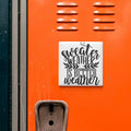 a vibrant orange wall with a white sign that reads "sweater weather is better".