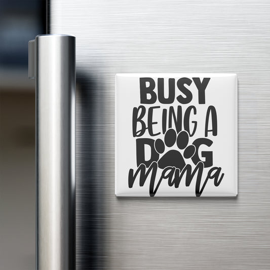 A white refrigerator magnet with the text "BUSY BEING A DOG MAMA" printed on it.