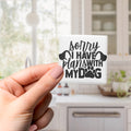 A person's hand holding a small white object with black text that says "Sorry I have plans with my dog".