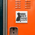 a sticker with the text "Dogs are my favorite people" on an orange surface, with a silhouette of a dog and the text in a black and white design.