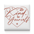 a heart-shaped design with the text "Be Kind to Yourself" written inside it.