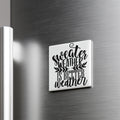 A white square magnet with the text " sweater weather is better weather" printed on it, mounted on a metallic surface.