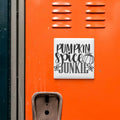 a close-up of an orange locker door with a white sign attached to it. The sign reads "Pumpkin spice junkie".