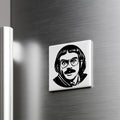 A black and white image of a man's face with glasses and a mustache is displayed on a metallic surface.