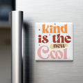 A white refrigerator magnet with the text "Kind is the new cool" in a colorful, retro-style font.