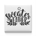 the text "sweater weather" in a stylized font, surrounded by decorative leaves.