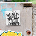 a white tile with black text that says "sweater weather is better weather".