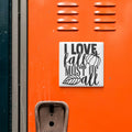 a sticker with the text "I LOVE fall MOST OF all" on an orange surface, with a metal vent and a small object below it.