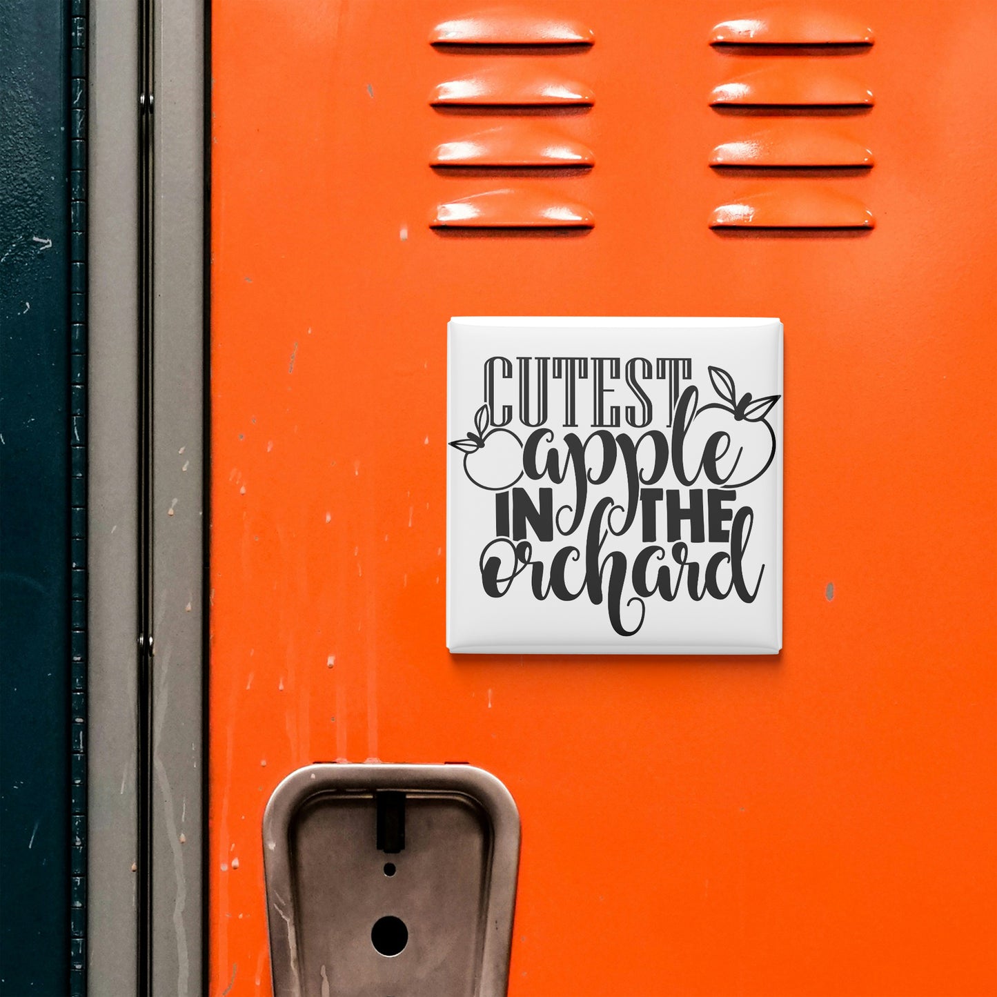 a vibrant orange wall with a white sign that reads "CUTEST APPLE IN THE ORCHARD" in a playful, artistic font.