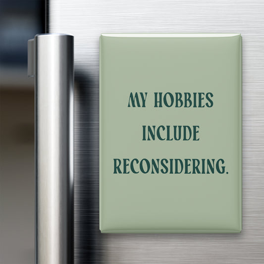 “My hobbies include reconsidering.” quote magnet displayed on a refrigerator