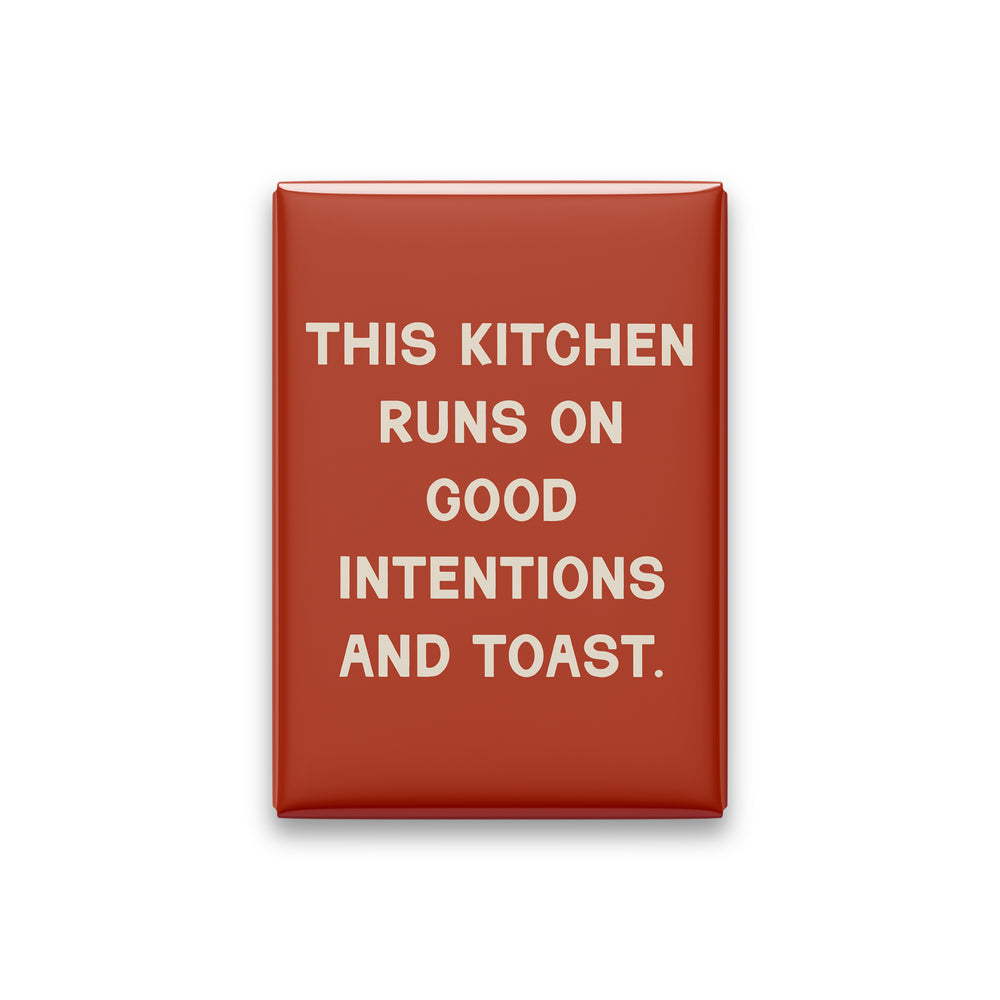 “This kitchen runs on good intentions and toast.” terracotta quote magnet on white