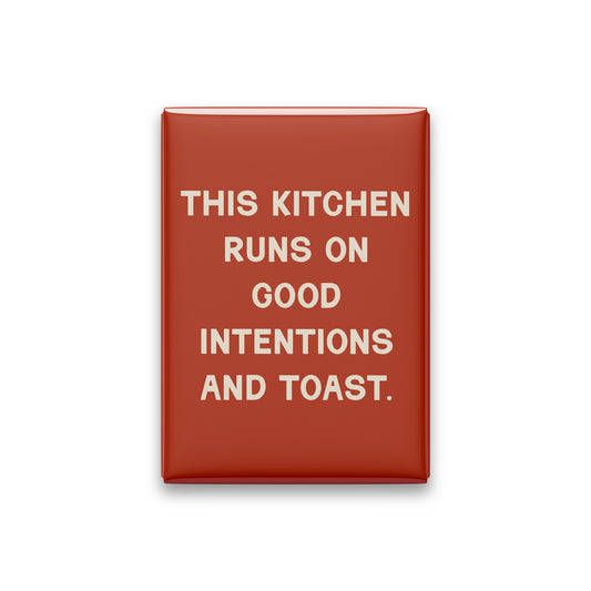 “This kitchen runs on good intentions and toast.” terracotta quote magnet on white