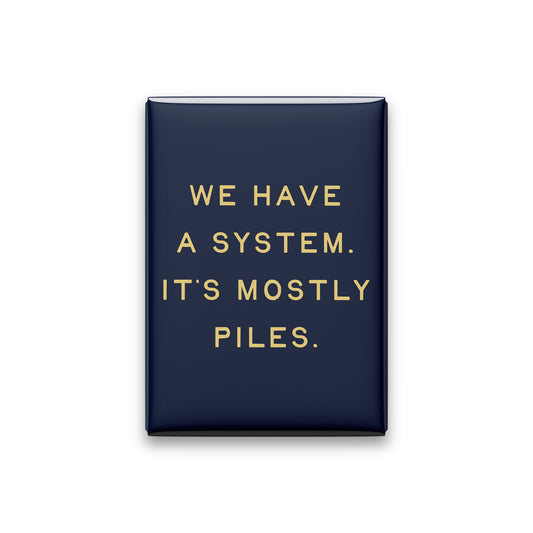 “We have a system. It's mostly piles.” midnight quote magnet on white