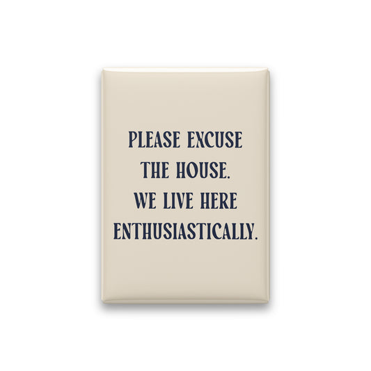 “Please excuse the house. We live here enthusiastically.” parchment quote magnet on white