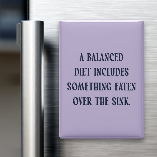 “A balanced diet includes something eaten over the sink.” quote magnet displayed on a refrigerator