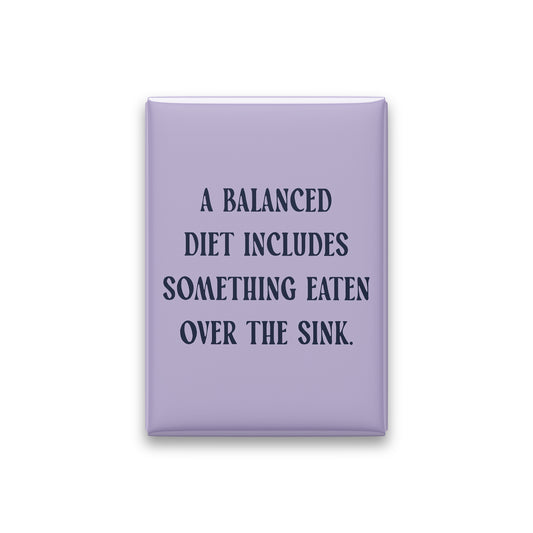 “A balanced diet includes something eaten over the sink.” lilac quote magnet on white