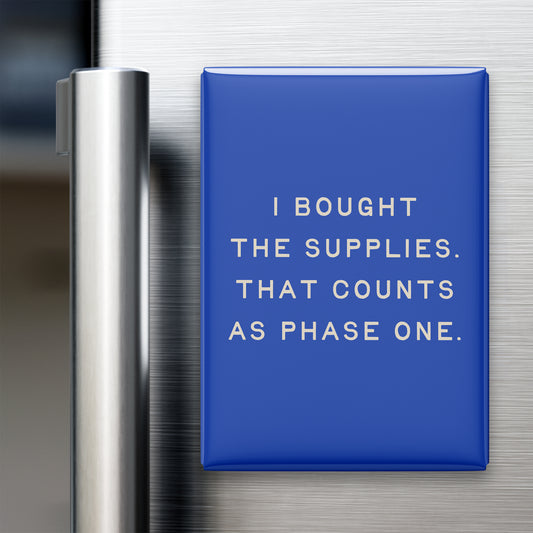 “I bought the supplies. That counts as phase one.” quote magnet displayed on a refrigerator