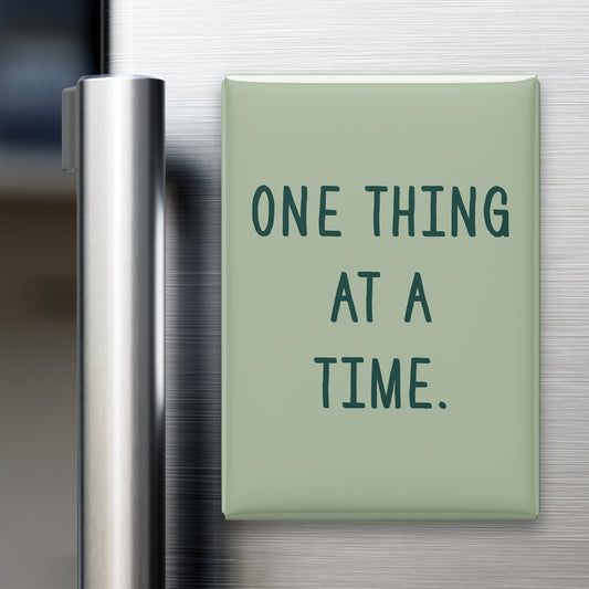 “One thing at a time.” quote magnet displayed on a refrigerator
