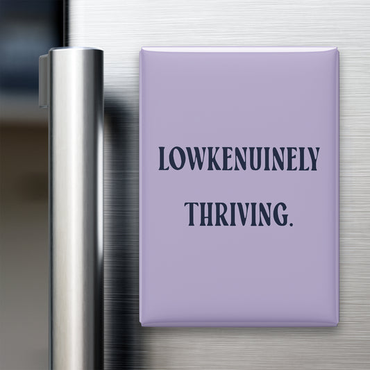 “Lowkenuinely thriving.” quote magnet displayed on a refrigerator