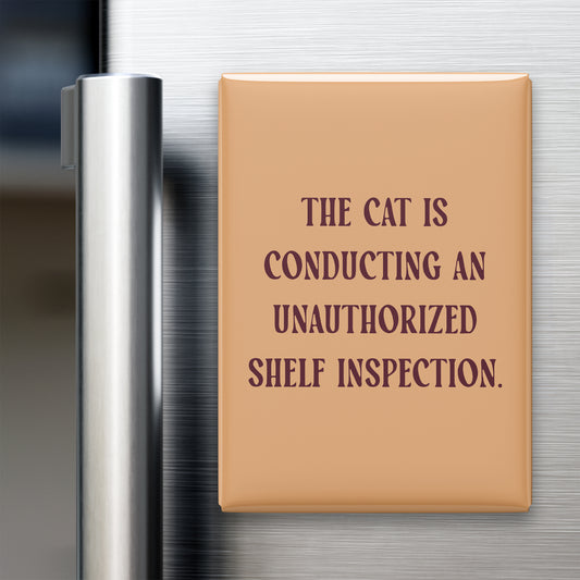 “The cat is conducting an unauthorized shelf inspection.” quote magnet displayed on a refrigerator