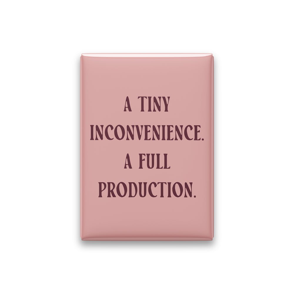 “A tiny inconvenience. A full production.” blush quote magnet on white
