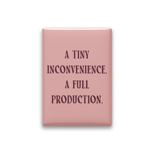 “A tiny inconvenience. A full production.” blush quote magnet on white