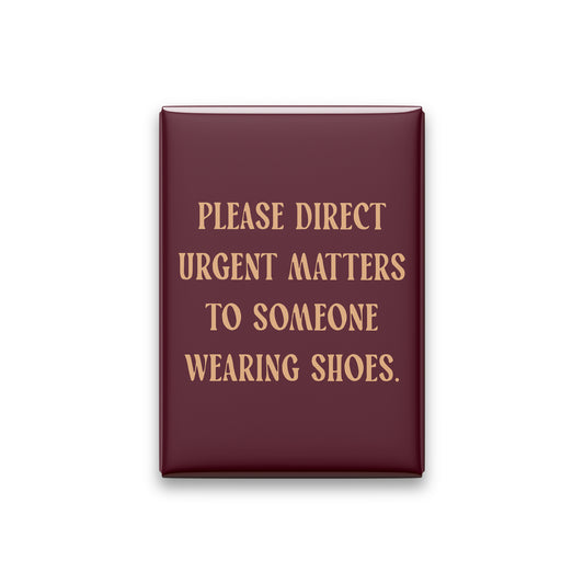 “Please direct urgent matters to someone wearing shoes.” oxblood quote magnet on white