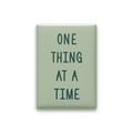 One Thing at a Time magnet in Spruce lettering on a Sage background, shown on white
