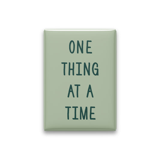 One Thing at a Time magnet in Spruce lettering on a Sage background, shown on white