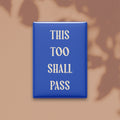 This Too Shall Pass magnet in Parchment lettering on a Cobalt background, shown on a warm neutral background