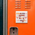 a vibrant orange wall with a white sign that reads "mama you are magic" in a playful font.