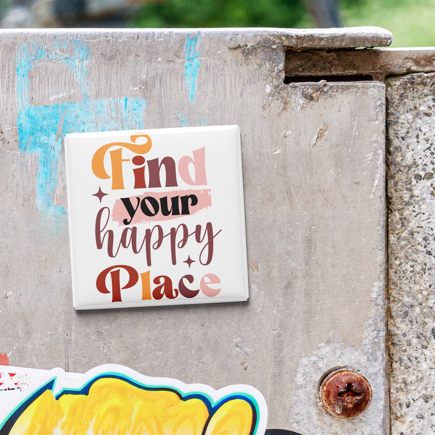 A sticker with the text "Find your happy place" is attached to a concrete wall.