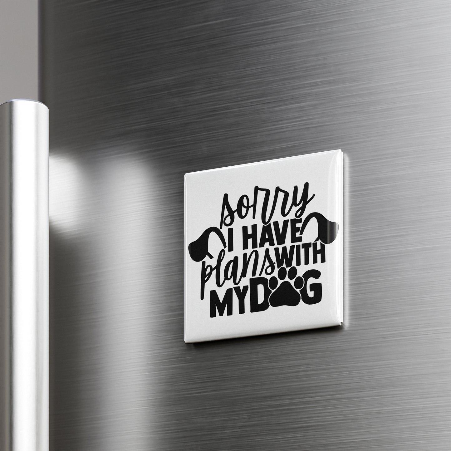 A white refrigerator magnet with the text "Sorry I have plans with my dog" printed on it.