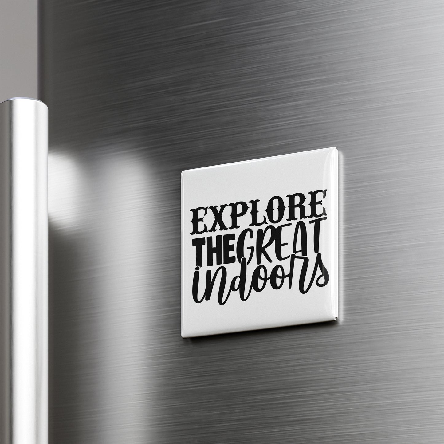 a refrigerator with a white square magnet that says "EXPLORE THE GREAT Indoors" in black text.