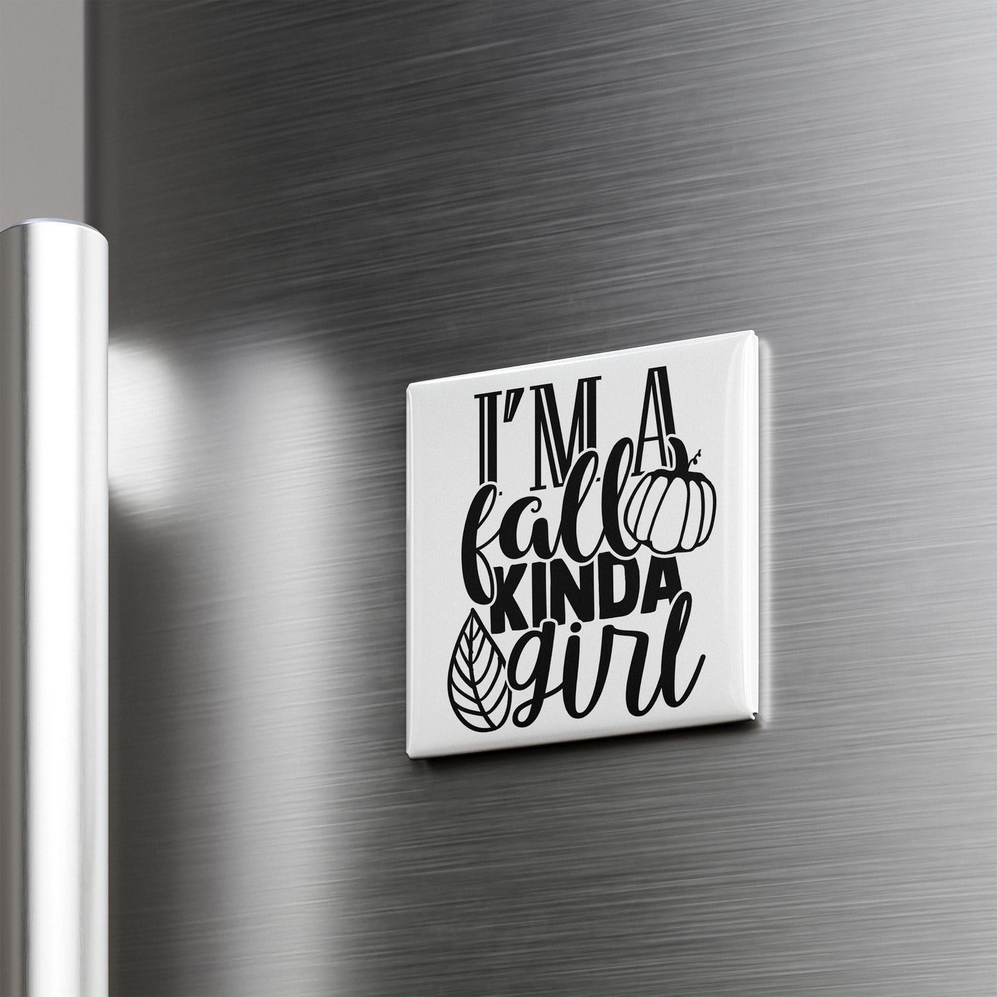 A white refrigerator magnet with the text "I'm a fall kinda girl" printed on it.