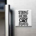 A white refrigerator magnet with the text "STAY AT HOME COT MOM" in black lettering.
