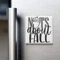 A white refrigerator magnet with the text "NOTS ABOUT FALL" printed on it.
