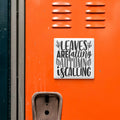 a vibrant orange wall with a white sign that reads "LEAVES AREFALLING AUTUMN IS CALLING" in a playful, artistic font.