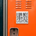 a bright orange surface with a sticker or sign that reads "I am not for everyone".