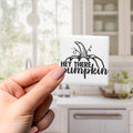 A hand holding a square magnet with the text "HEY THERE PUMPKIN" on it.